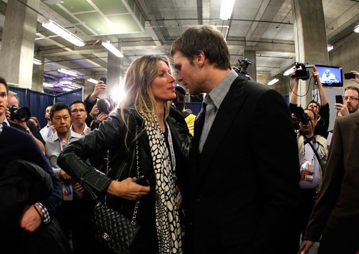 Gisele Bundchen and Tom Brady share a moment before his postgame news conference at the Super Bowl last winter.