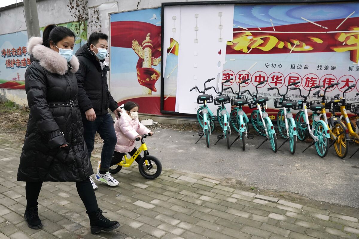Residents walk past a row of bicycles in Wuhan.