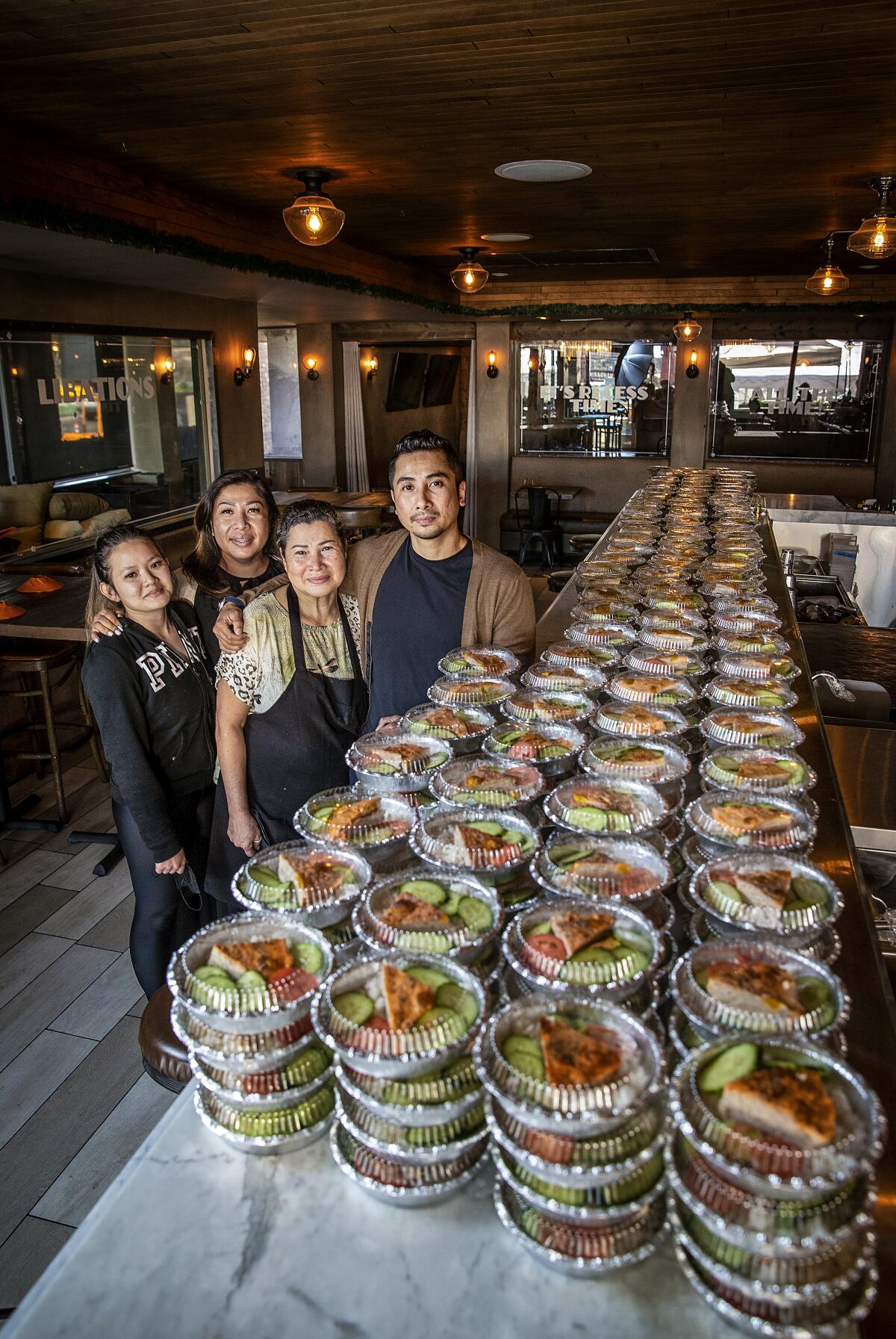 Nhi Huynh, Huong Pham, Kim Huynh and Viet Pham, stand with about 600 Han Vi meals