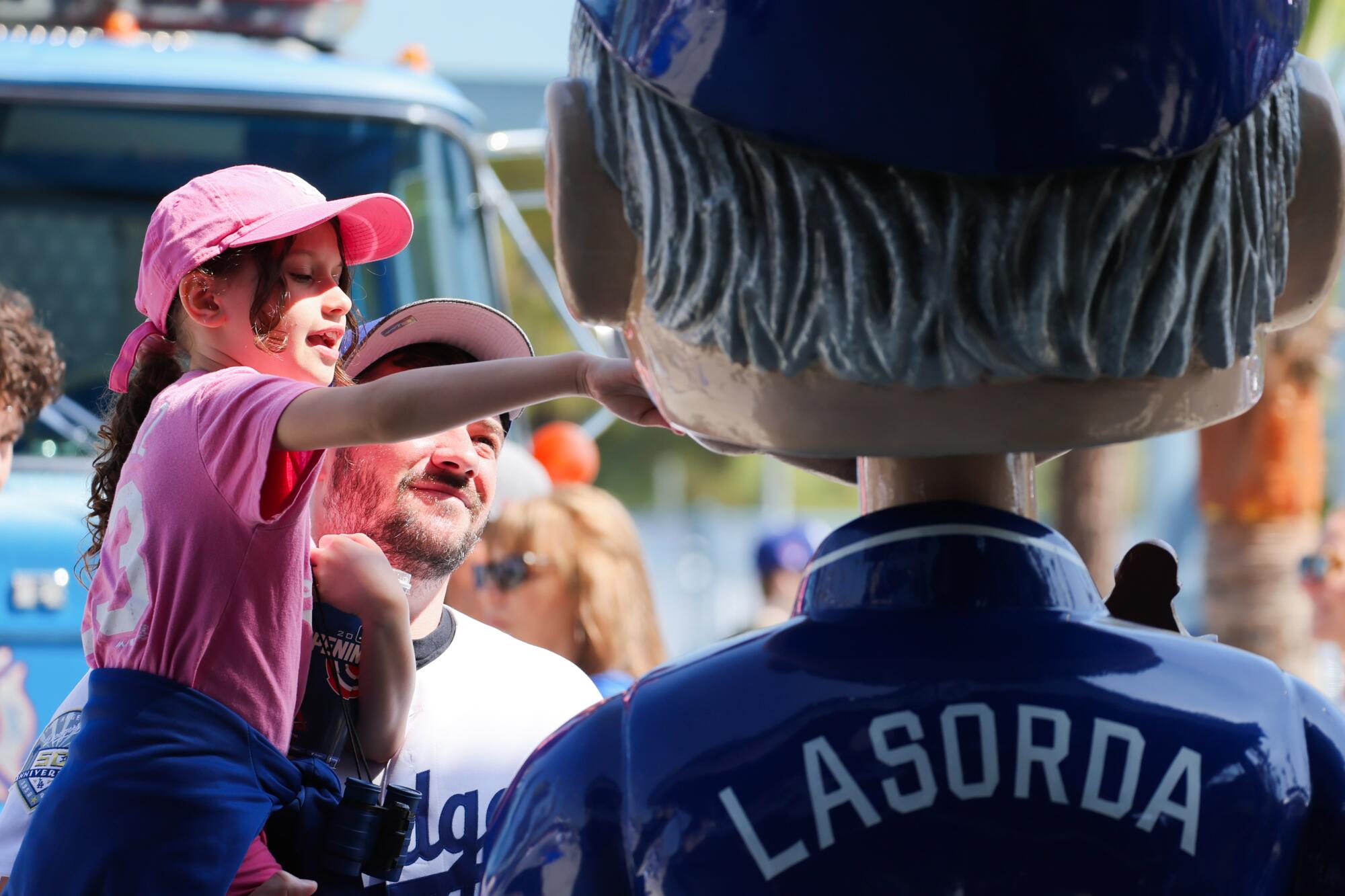 Juliana Faber and her father Nick Faber play with a large Tommy Lasorda bobblehead.