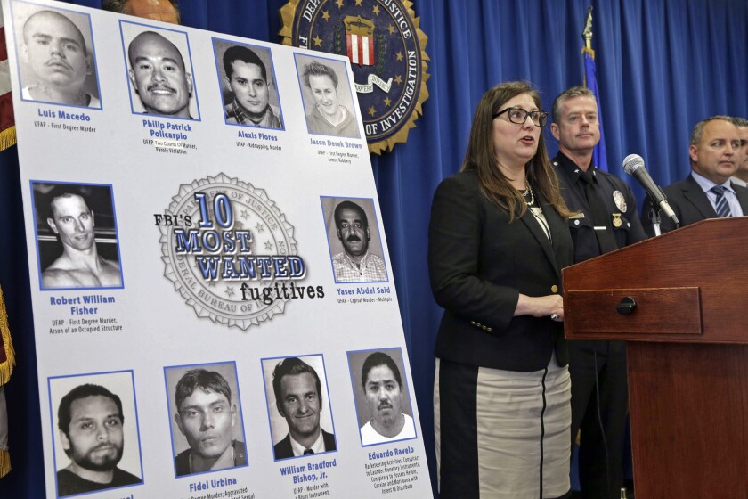 FBI Assistant Director in Charge Deirdre Fike, left, with L.A. Police Cmdr. Todd Chamberlain, second from left, confirm Philip Patrick Policarpio was added to the FBI's Top 10 Most Wanted Fugitives list on May 19. Policarpio was arrested 10 days later at the Mexican border.