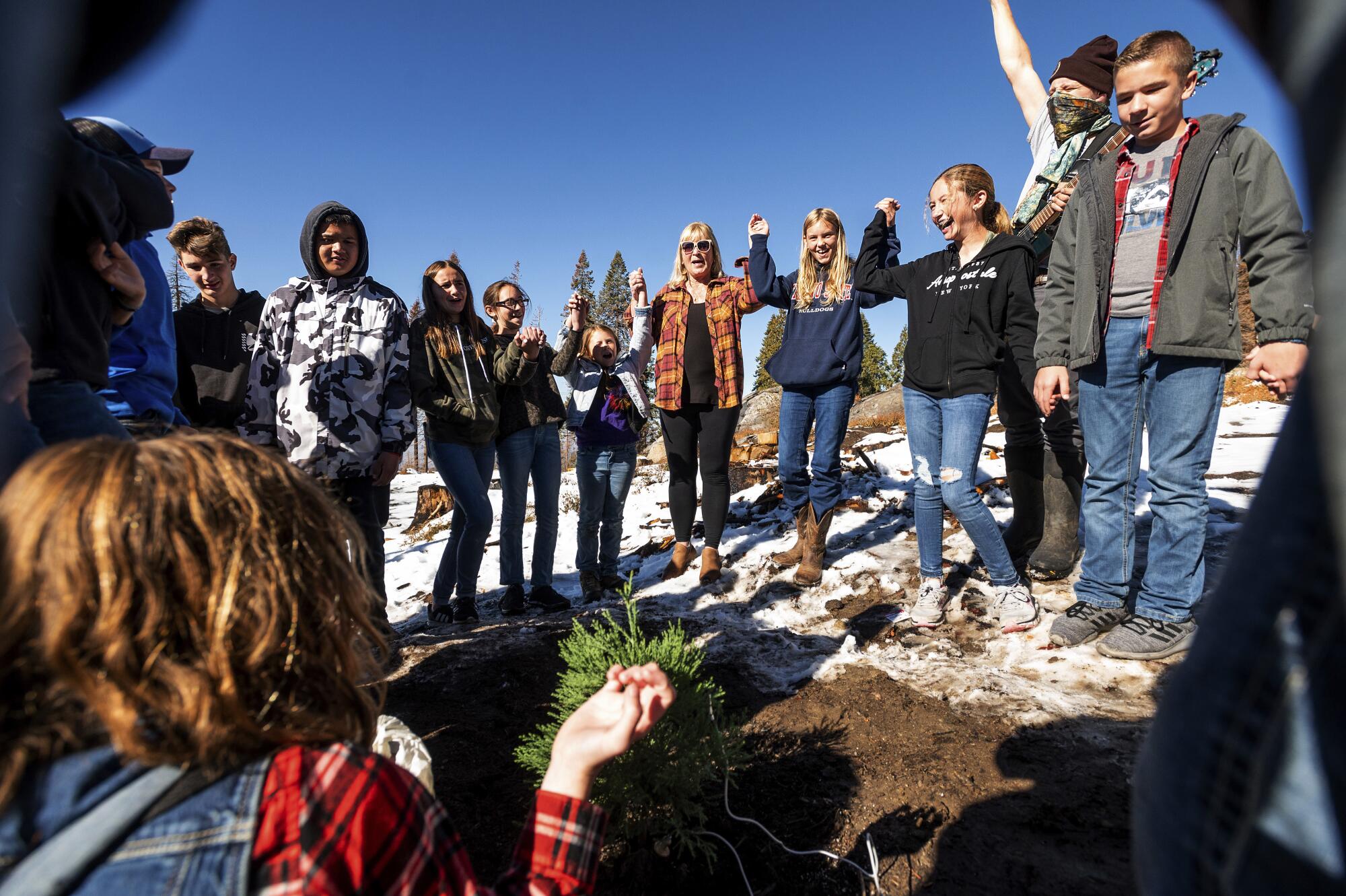 Students from Springville Elementary School gather around a newly planted sequoia seedling.