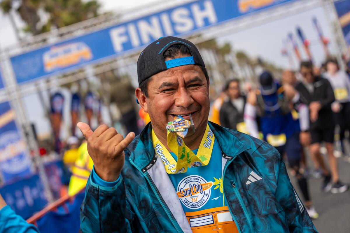 A man gives a "shaka" sign after finishing the Surf City Marathon on Sunday morning.