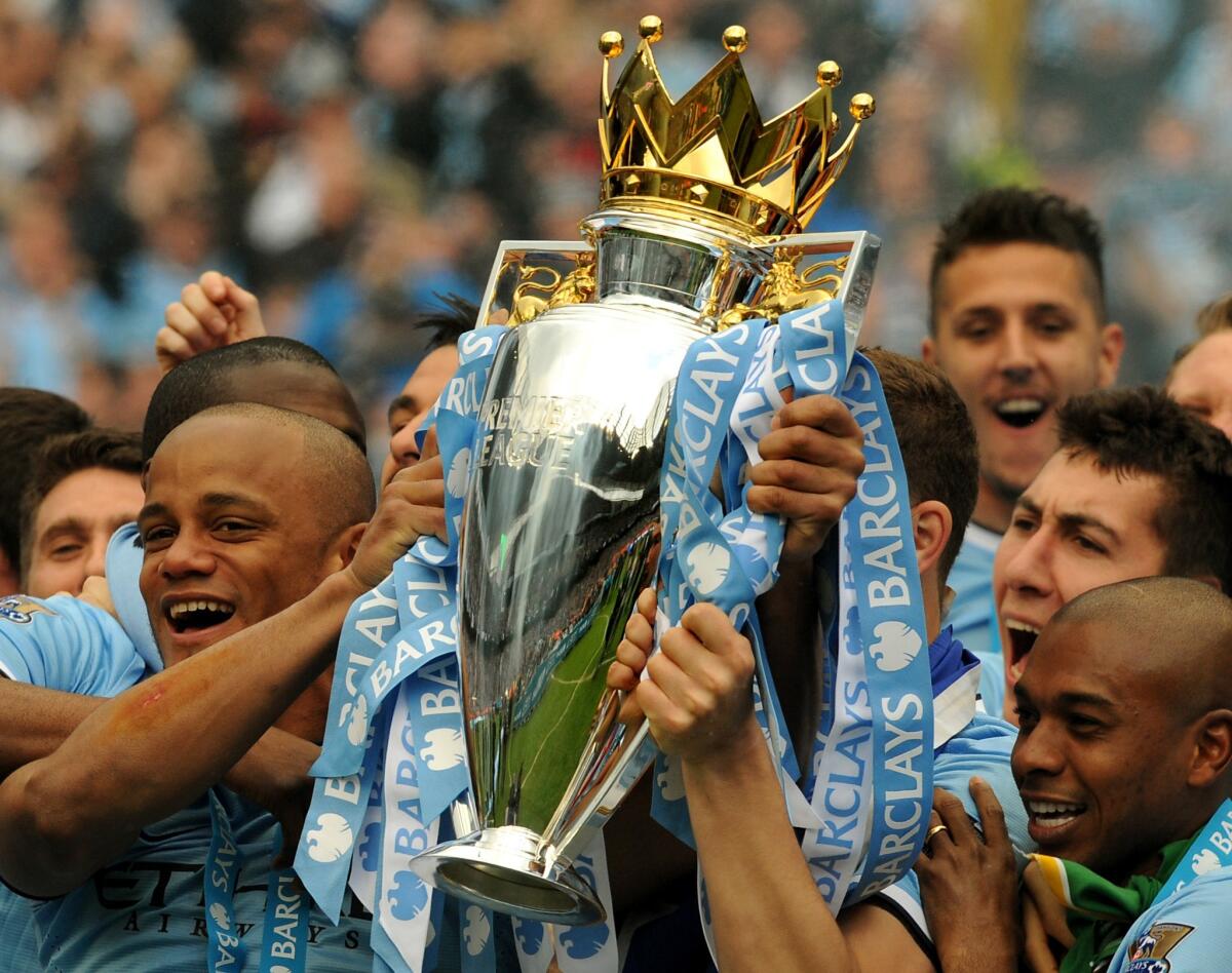 Manchester City's Vincent Kompany celebrates with the Premier League trophy after clinching the team's second title in three years with a 2-0 win Sunday over West Ham United.