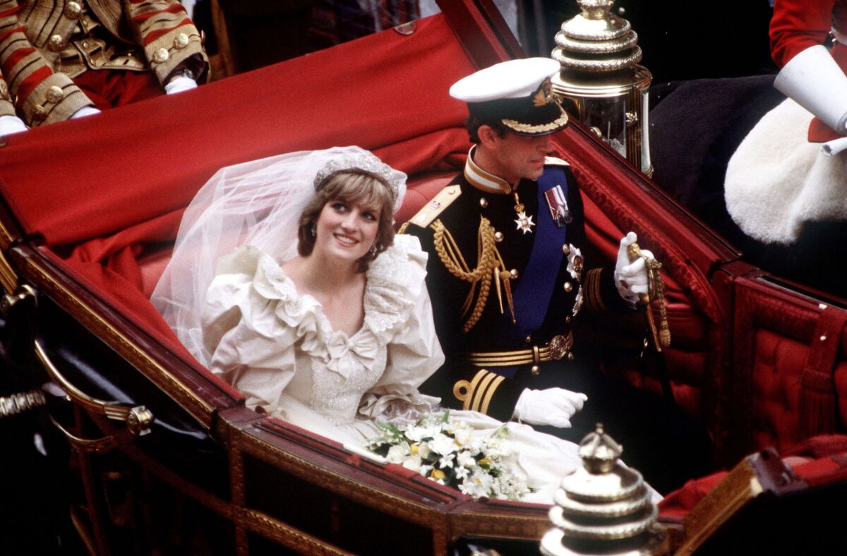 Prince Charles and Princess Diana ride in an open coach on their wedding day in 1981.