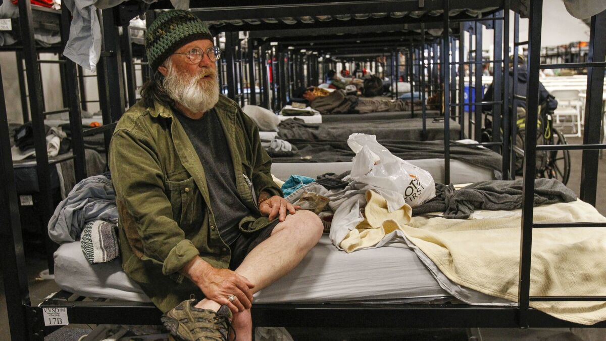 Jeffrey Bennatts, 70, a Navy veteran, sits on his bed at a shelter tent for homeless veterans in San Diego on Thursday.