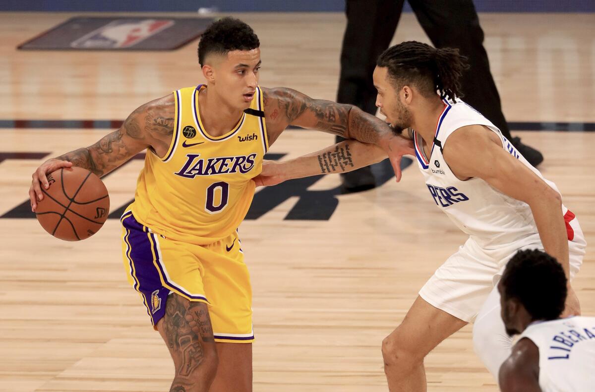 Kyle Kuzma (0) is defended by Amir Coffey (7) during the third quarter.