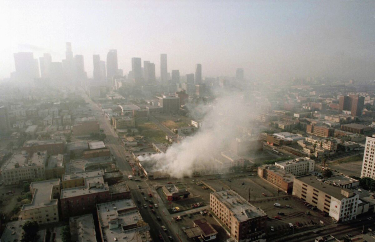 In this April 30, 1992 file photo, smoke rises from a shopping center burned by rioters in Los Angeles after four police officers had been acquitted of the 1991 beating of motorist Rodney King.
