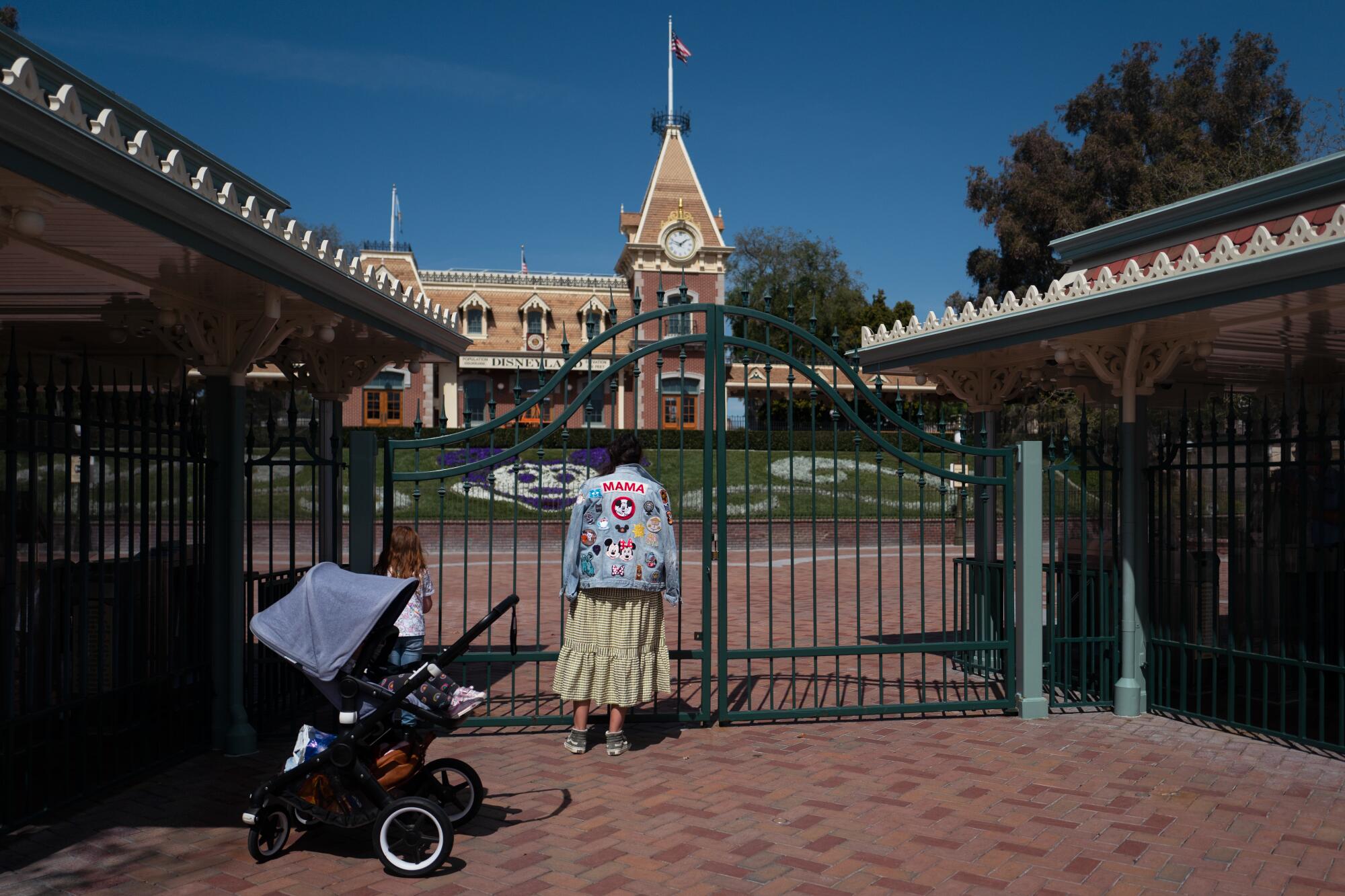 A person standing outside the gates of Disneyland.