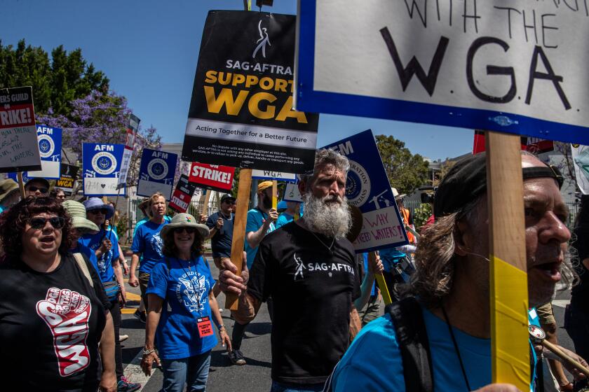 LOS ANGELES, CA - JUNE 21: Actor John Tebbens, in beard, a member of SAG-AFTRA, in support of striking members of the Writers Guild of America marches for a rally at La Brea Tar Pits, Los Angeles, CA. (Irfan Khan / Los Angeles Times)
