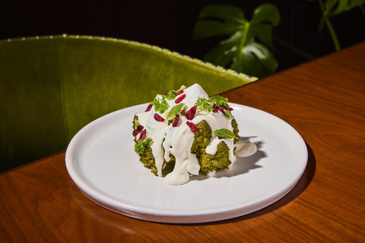 Roasted romanesco topped with almond cream and pomegranate seeds