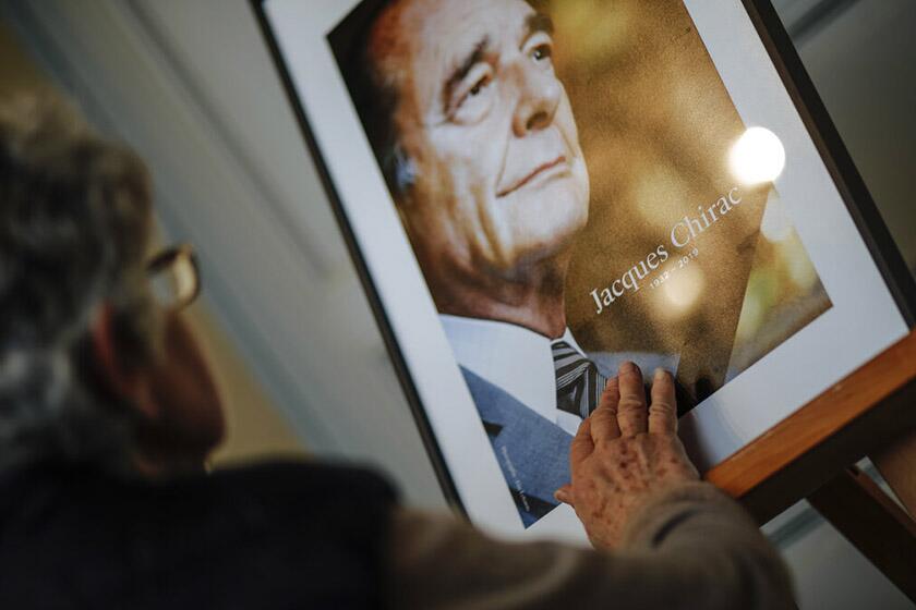 A woman pays tribute to late French President Jacques Chirac at the Invalides monument in Paris on Sunday.