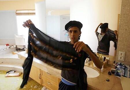 A man holds clothes in the house of Aisha, the daughter of Libyan leader Muammar Gaddafi in Tripoli.