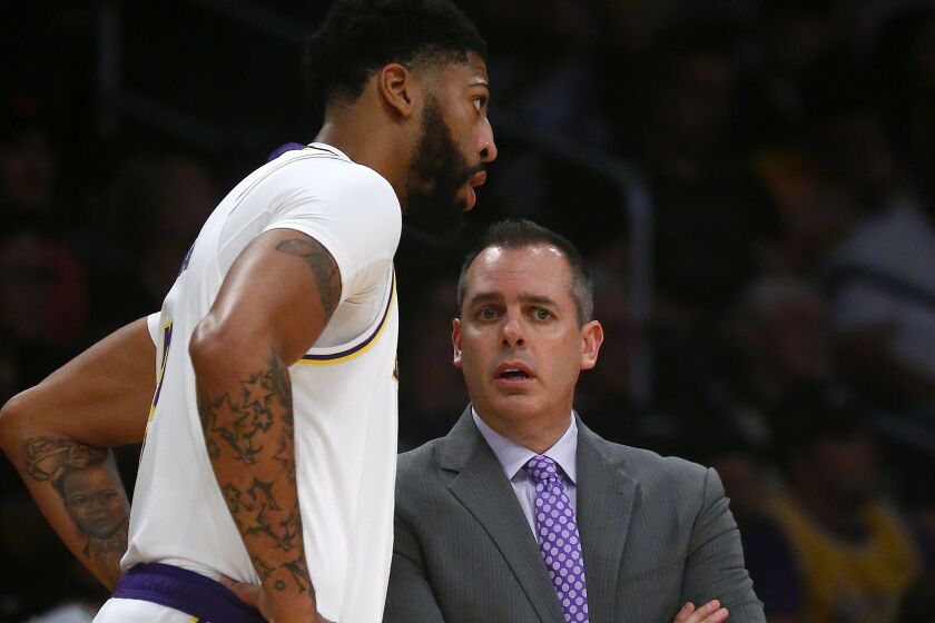 Lakers forward Anthony Davis chats with coach Frank Vogel during a game earlier this season.