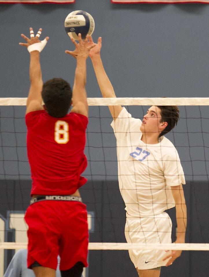 Corona del Mar High's Brandon Browning (27) tips the ball past a Cathedral Catholic middle blocker.