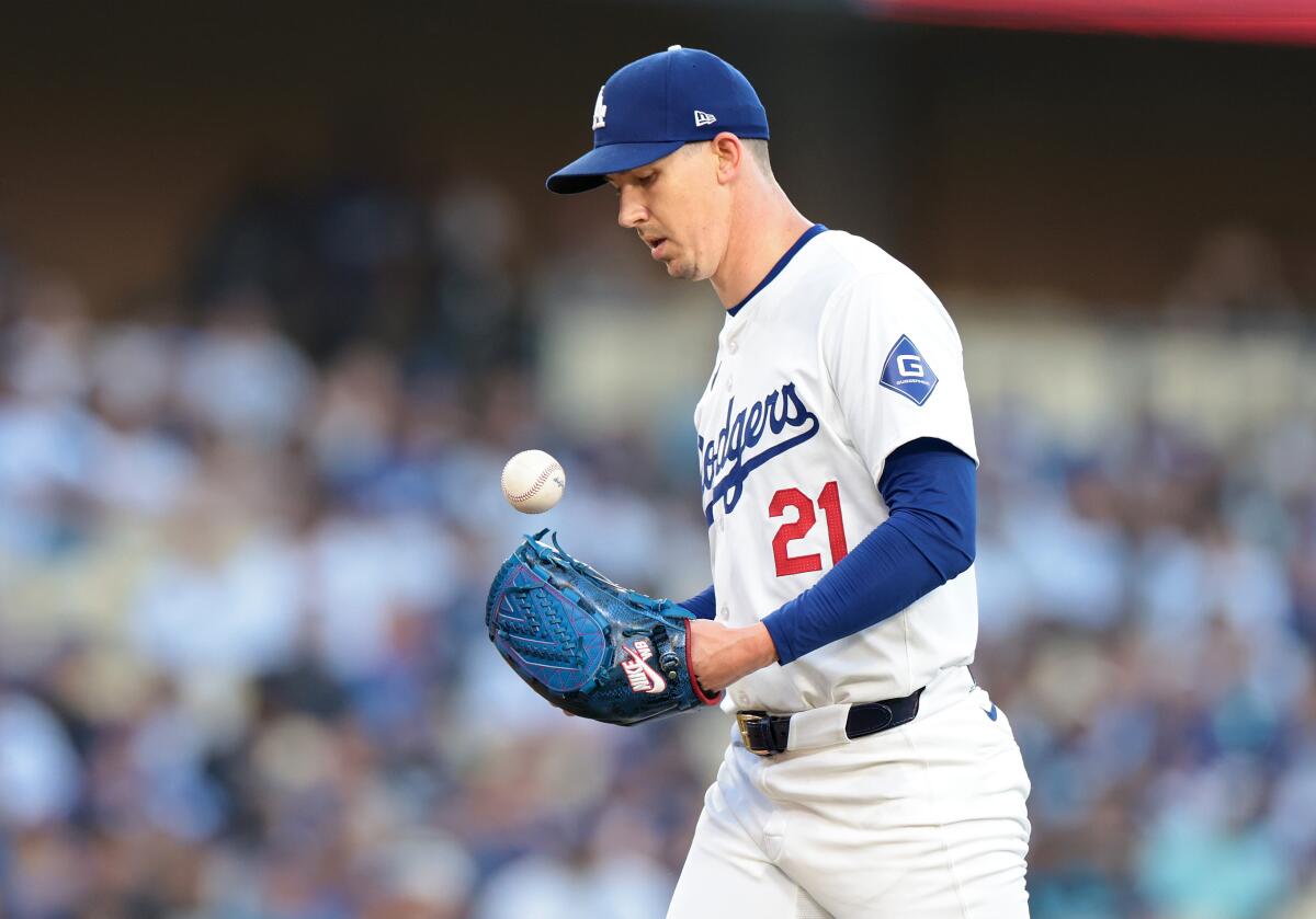 Dodgers pitcher Walker Buehler walks back to the mound after giving up a hit against the Texas Rangers on June 13.