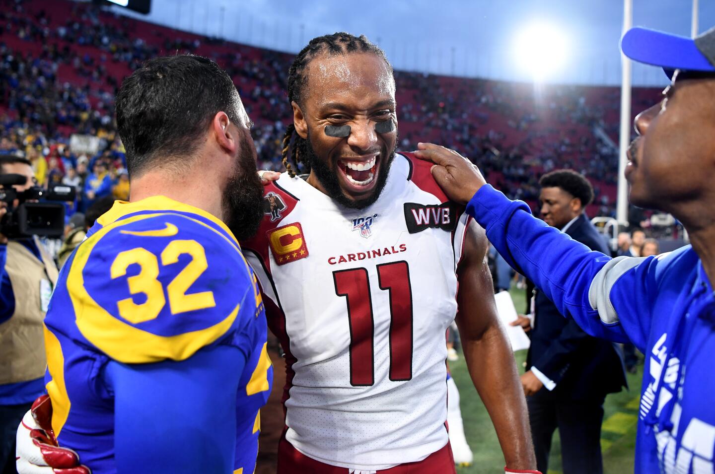 Arizona Cardinals wide receiver Larry Fitzgerald and Rams safety Eric Weddle share a laugh after the Rams' 31-24 victory at the Coliseum.