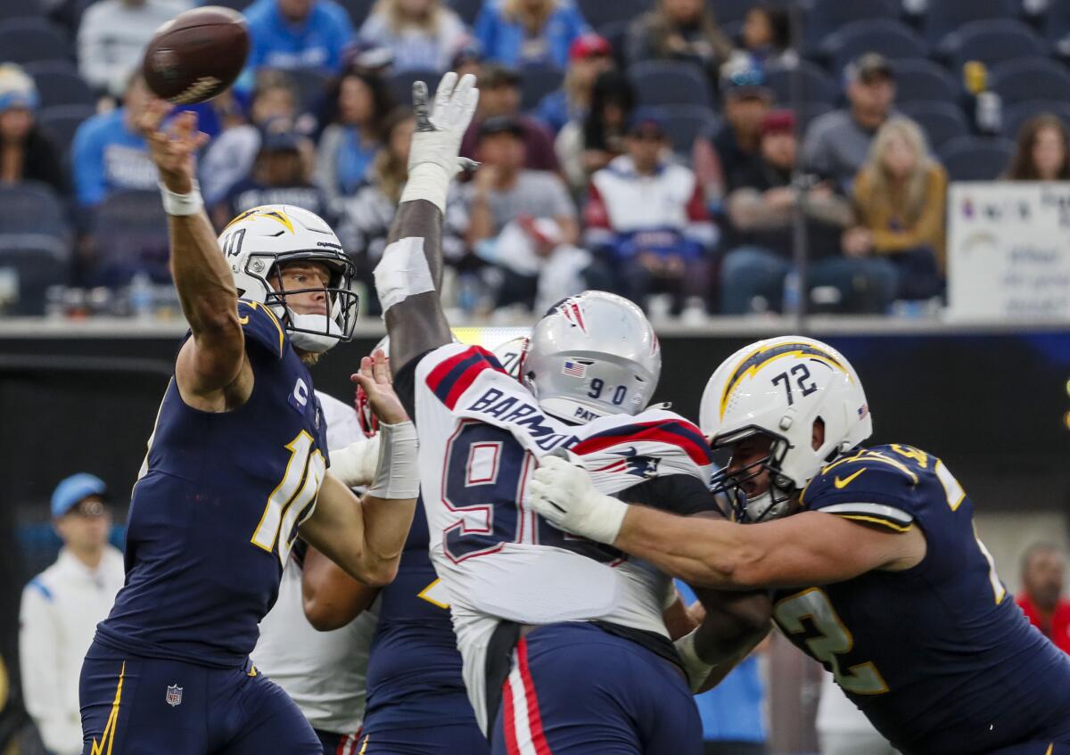 Chargers quarterback Justin Herbert (10) passes under pressure against the New England Patriots.
