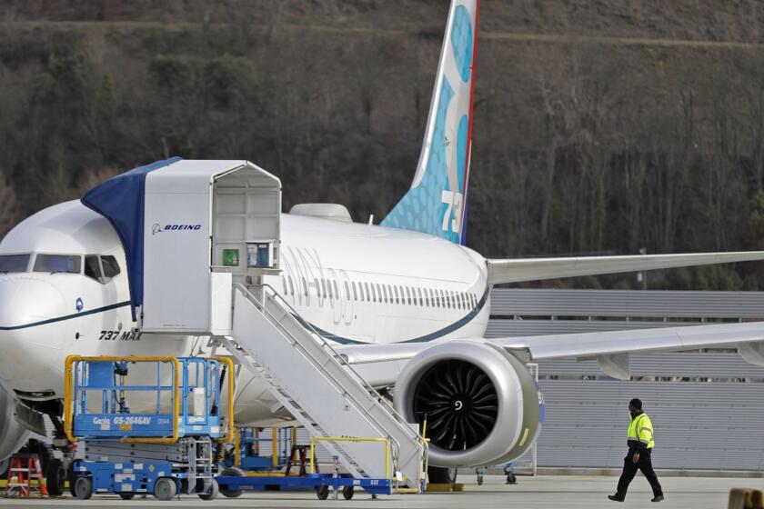 A worker walks next to a Boeing 737 MAX 8 airplane parked at Boeing Field, Thursday, March 14, 2019, in Seattle. The fatal crash Sunday of a 737 MAX 8 operated by Ethiopian Airlines was the second fatal flight for a Boeing 737 Max 8 in less than six months, and more than 40 countries, including the U.S., have now grounded the planes or refused to let them into their airspace. (AP Photo/Ted S. Warren)