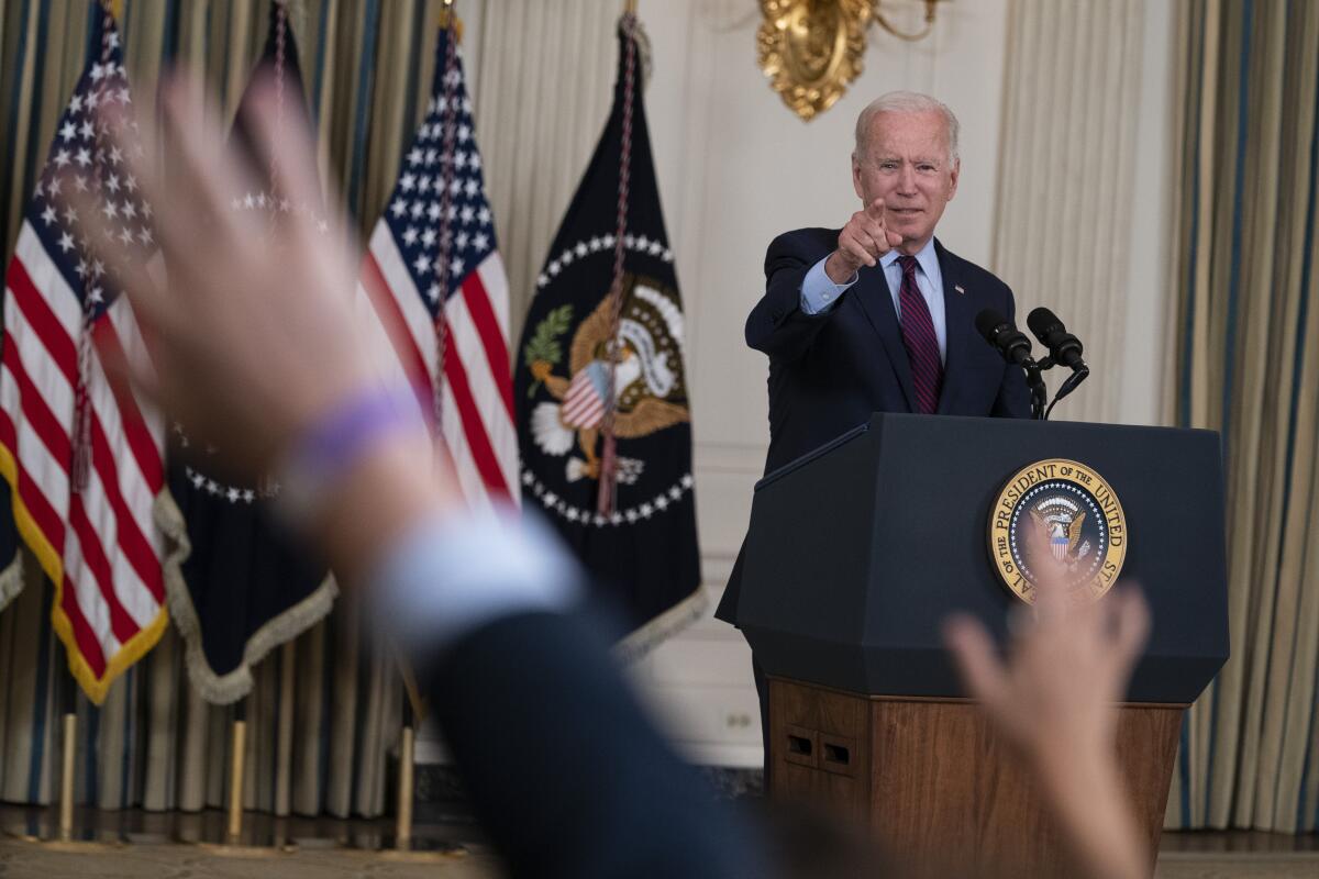 President Biden points during a news conference.