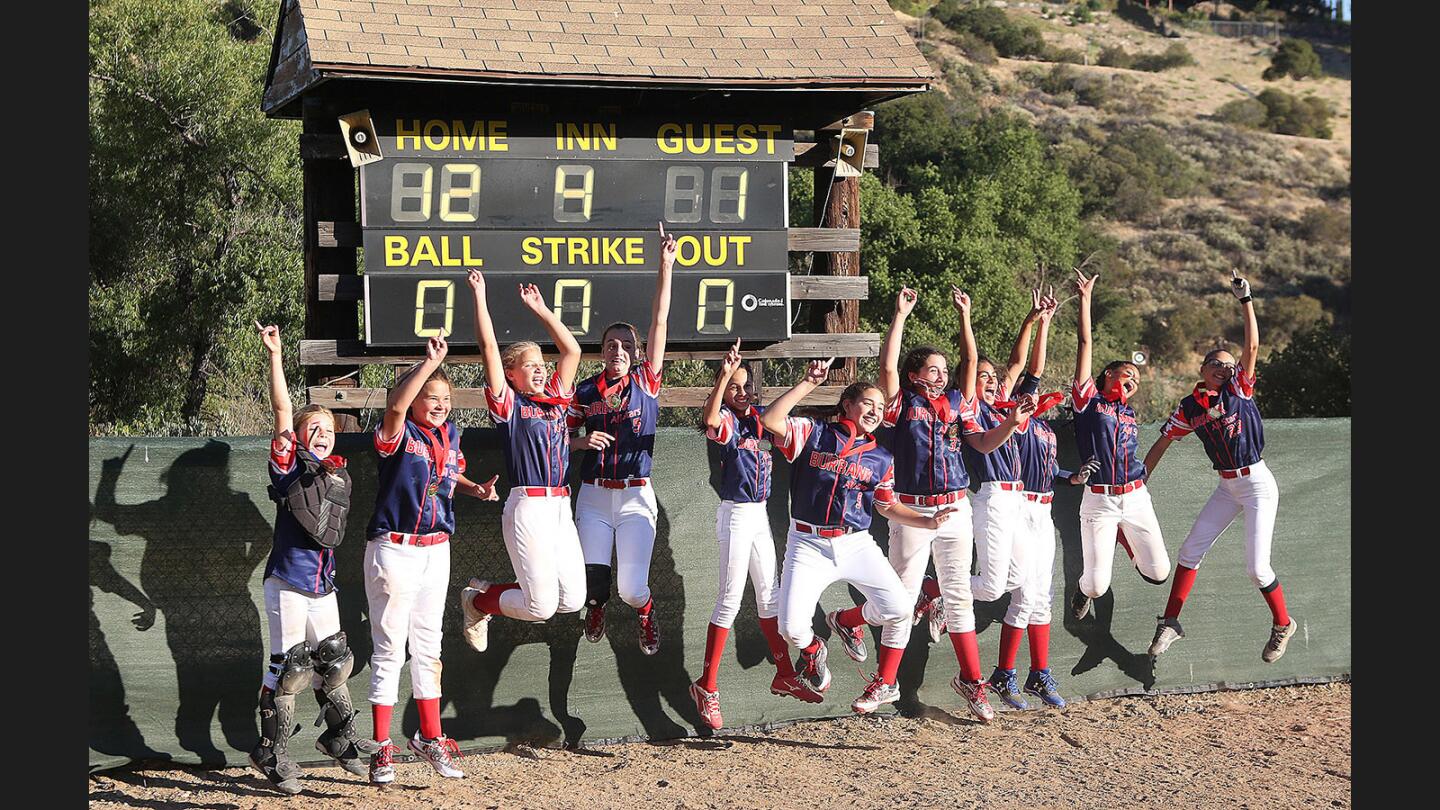 Burbank-Jewel City's jumps in front of the scoreboard, victorious over Rosamond in the District 2 9-11 softball championship at Tujunga Little League Fields on Monday, July 3, 2017. Burbank-Jewel City won the game 12-1.