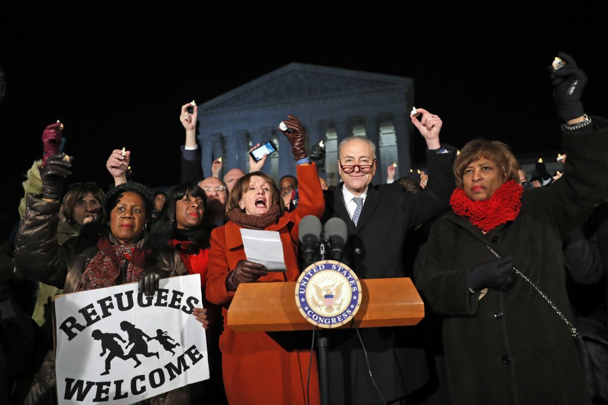 Rep. Sheila Jackson Lee D-Texas, left, House Minority Leader Nancy Pelosi of Calif., Senate Minority Leader Chuck Schumer of New York, Rep. Brenda Lawrence, D-Mich., right, and other members of Congress, hold small candles aloft in front of the Supreme Court during a news conference about President Donald Trump's recent executive orders Jan. 30, 2017 in Washington, D.C.