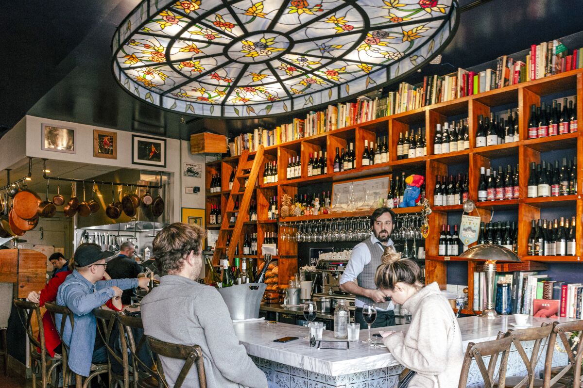 A restaurateur works behind a busy bar