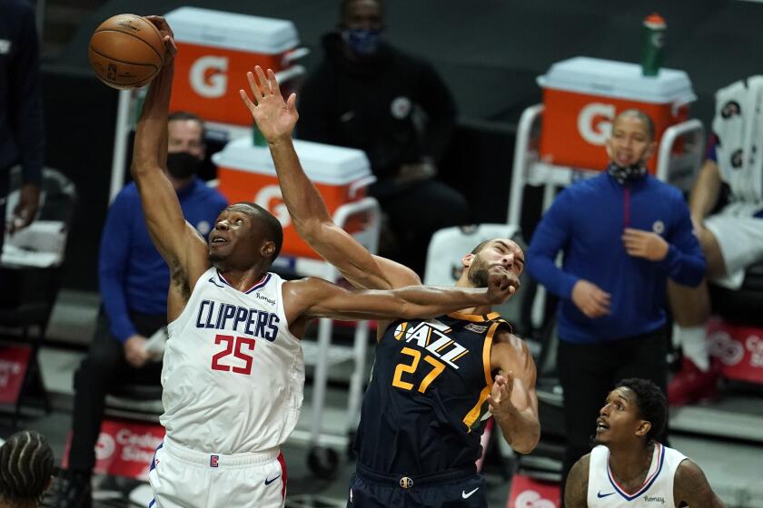 Los Angeles Clippers forward Mfiondu Kabengele (25) shoots over Utah Jazz center Rudy Gobert (27) during the first half of an NBA preseason basketball game Thursday, Dec. 17, 2020, in Los Angeles. (AP Photo/Marcio Jose Sanchez)