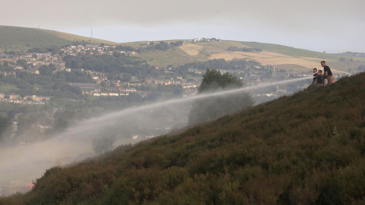 Firefighters battle a wildfire in northwest England during a heat wave on June 27.