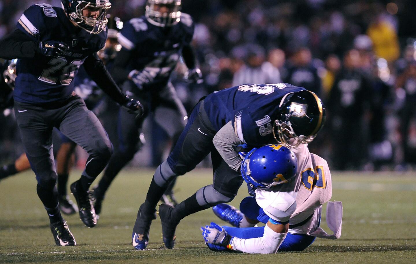 St. John Bosco’s Tyrel Thomas brings down Bishop Amat’s Trevon Sidney during a Pac-5 Division football semifinal on Friday night at Cerritos College.