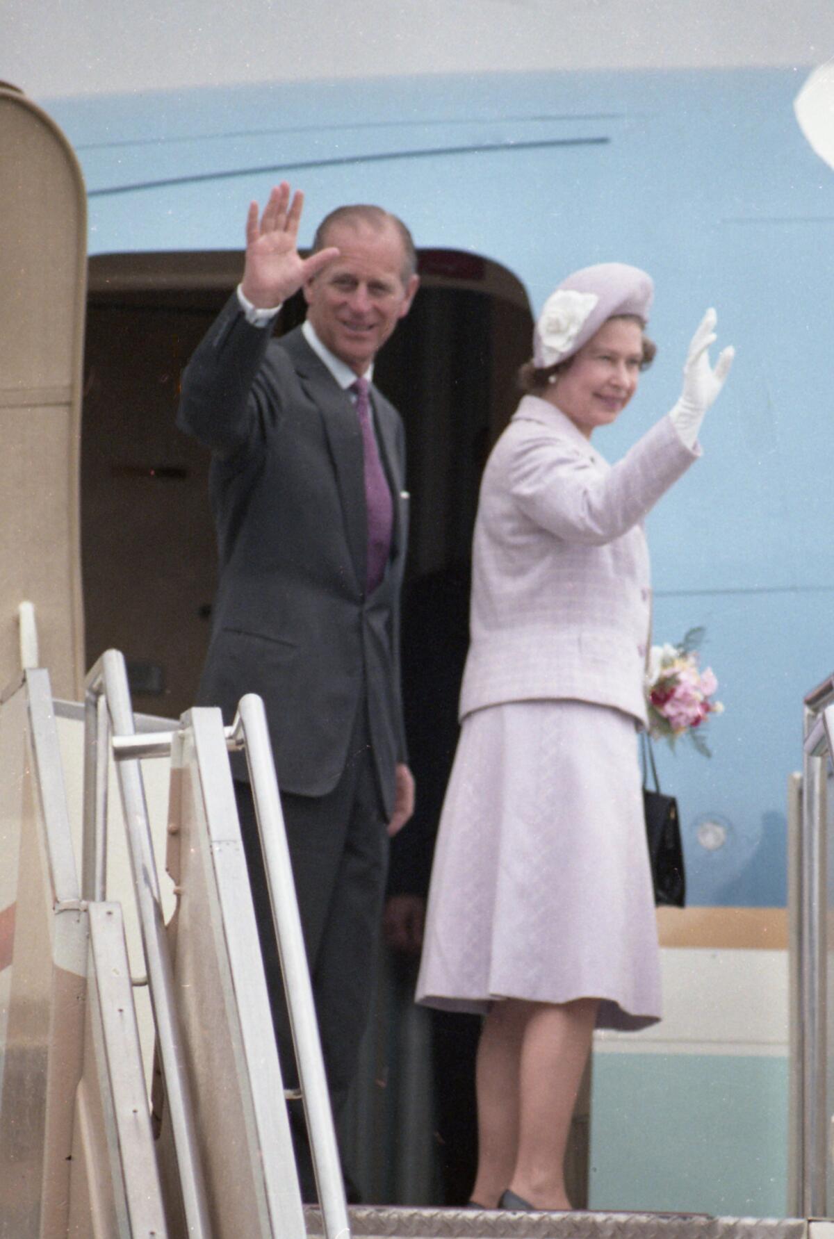 Queen Elizabeth and Prince Philip wave farewell at the door of Air Force Two  