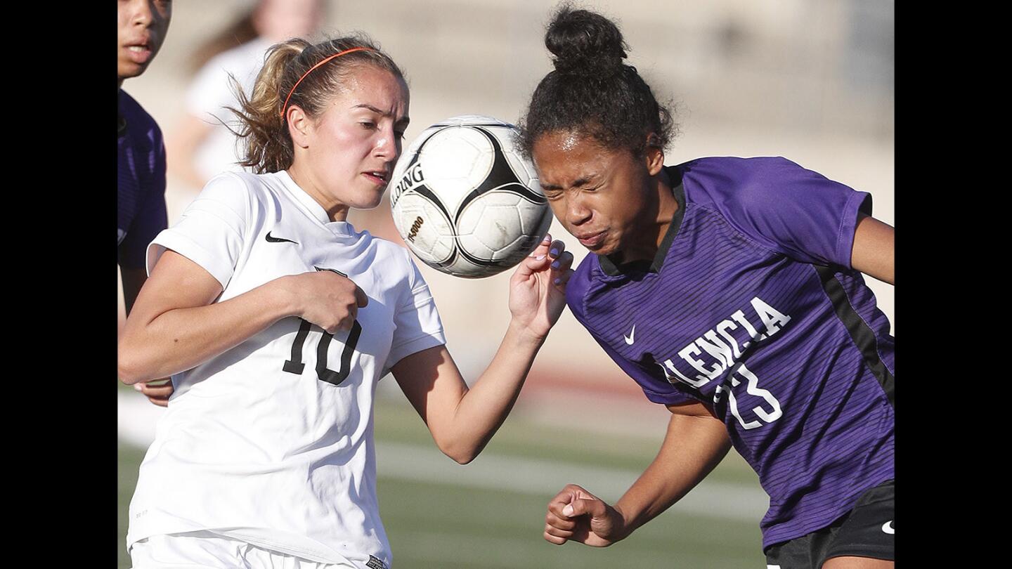 Flintridge Sacred Heart Academy's Marissa Venneri has the ball swept from her off of the head of Valencia's Catherine Edwards in a CIF Southern Section Division II first-round girls' soccer game at Occidental College on Thursday, February 15, 2018.