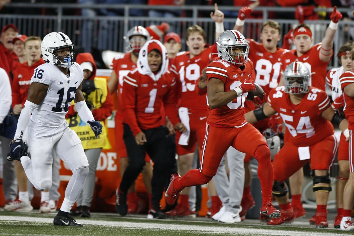 Ohio State running back TreVeyon Henderson, right, outruns Penn State defensive back Ji'Ayir Brown before being pushed out of bounds during the second half of an NCAA college football game Saturday, Oct. 30, 2021, in Columbus, Ohio. Ohio State won 33-24. (AP Photo/Jay LaPrete)