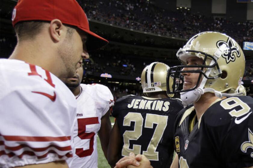 San Francisco's Alex Smith, left, shown shaking hands with New Orleans' Drew Brees, remained on the sidelines during the 49ers' victory over the Saints on Sunday.