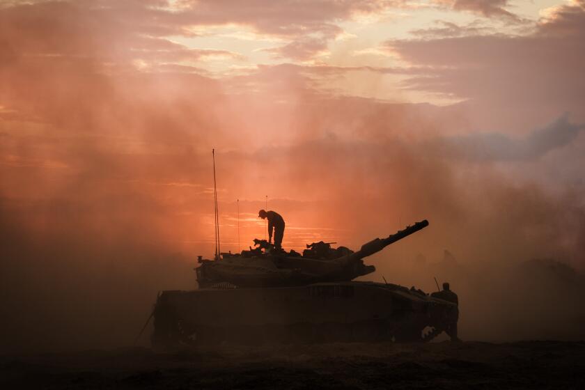 BE'ERI, ISRAEL -- OCTOBER 14, 2023: Israeli Merkava battle tank units regroup near the border of Gaza, in the southern part of Israel, Saturday, Oct. 14, 2023. Israel was caught by surprise after Hamas launched an unprecedented assault on communities near Gaza which led to the deadliest bout of violence to hit Israel in 50 years that has taken more than a thousand lives on both sides. Now, IsraelOs military prepares for a wide scale incursion into Gaza in the countryOs south. (MARCUS YAM / LOS ANGELES TIMES)
