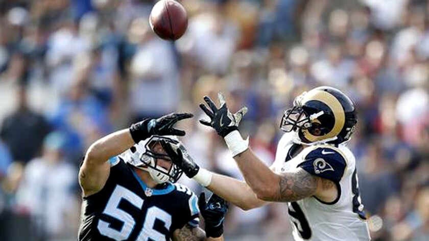 Rams tight end Tyler Higbee hauls in a 31-yard pass over Panthers linebacker A.J. Klein during first-half action.