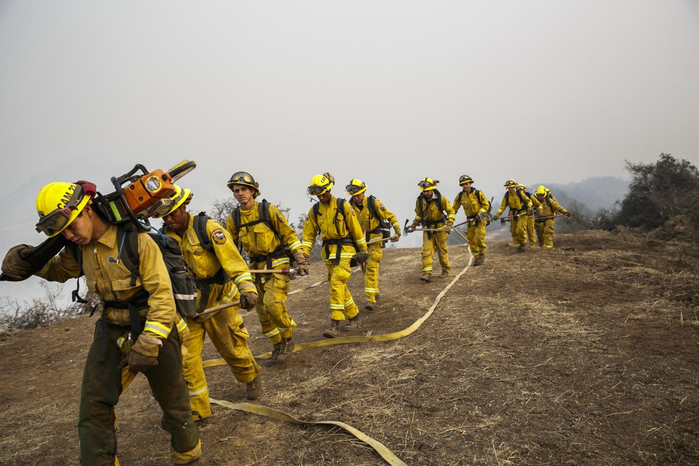 Firefighters return during a shift change after working overnight, conducting burnout operations to corral the Sherpa fire in El Capitan Canyon in Goleta on June 18, 2016.