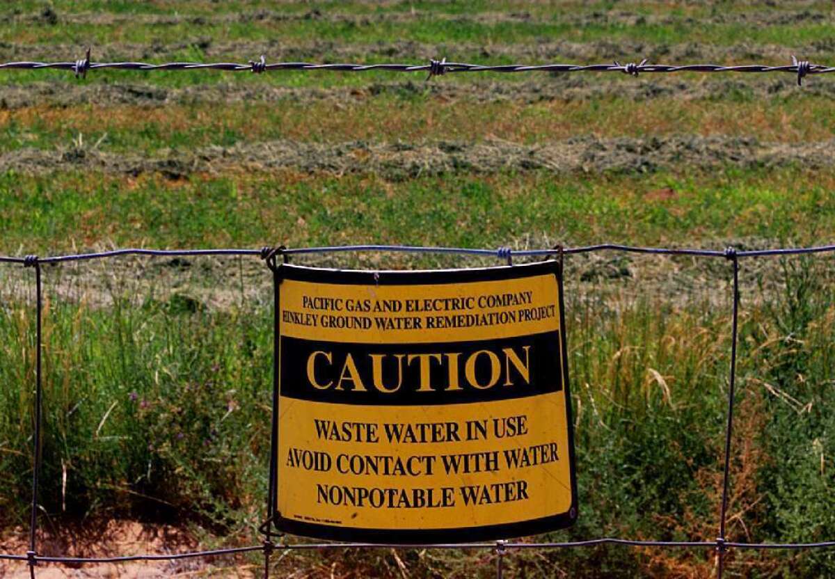 Caution signs hang on a fence surrounding a Hinkley, Calif., farm that uses irrigation water polluted with chromium, a carcinogen. California health officials are adopting the nation's first-ever drinking water standard for hexavalent chromium, which is found in water supplies across the state.