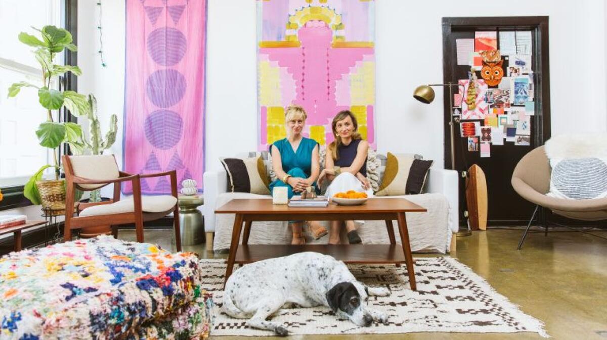 Textile designers Hopie and Lily Stockman sit on a couch.