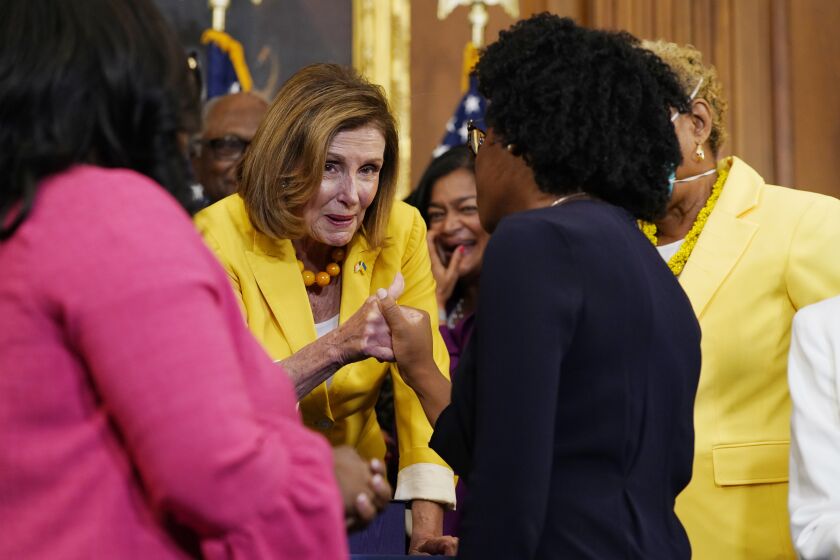 House Speaker Nancy Pelosi of Calif., surrounded by House Democrats, after the Inflation Reduction Act of 2022 bill enrollment ceremony on Capitol Hill in Washington, Friday, Aug. 12, 2022.(AP Photo/Mariam Zuhaib)
