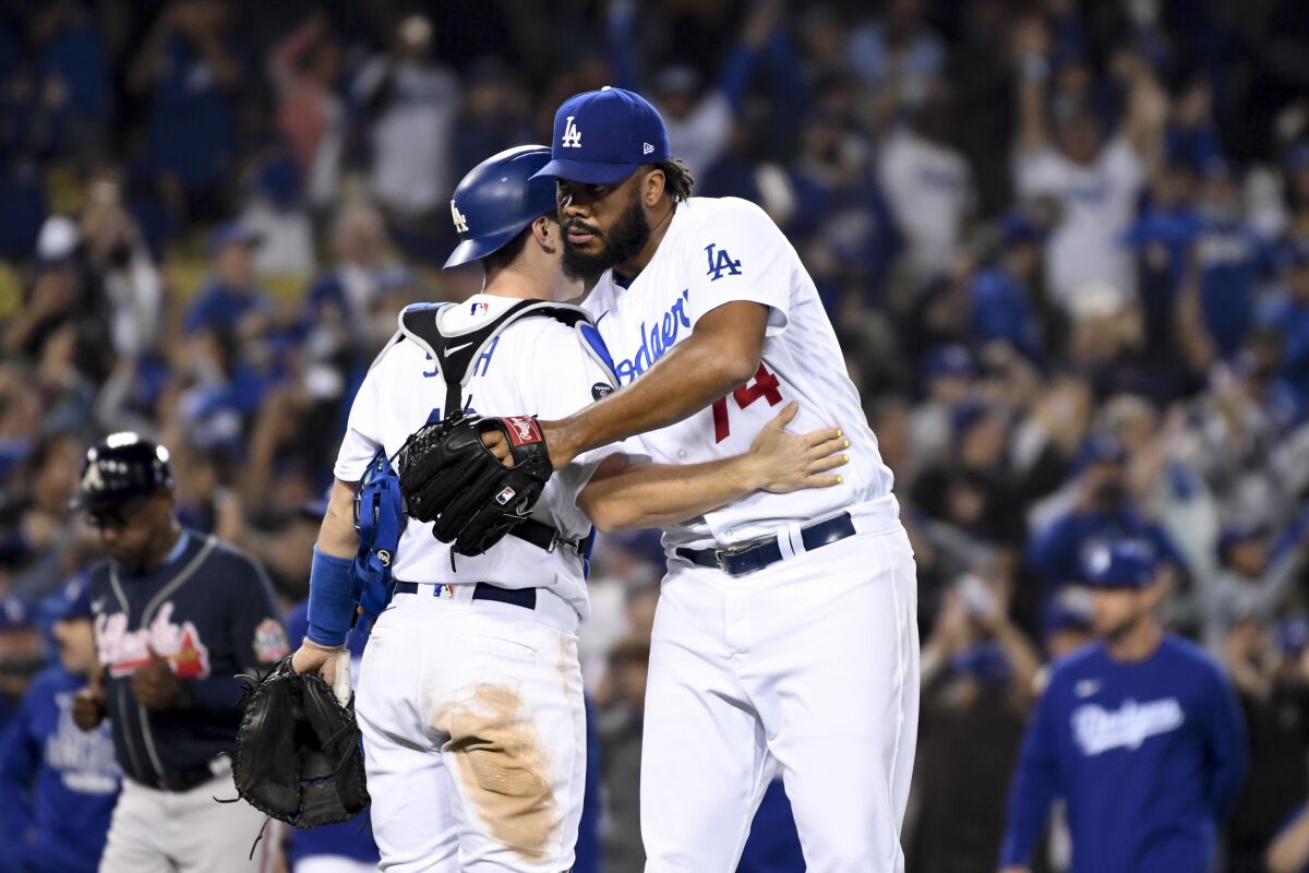 Dodgers' Kenley Jansen hugs catcher Will Smith after defeating the Atlanta Braves.
