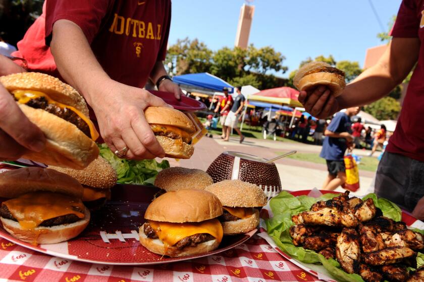 Burgers, chipotle chicken wings served with blue cheese dip at a USC tailgate party.