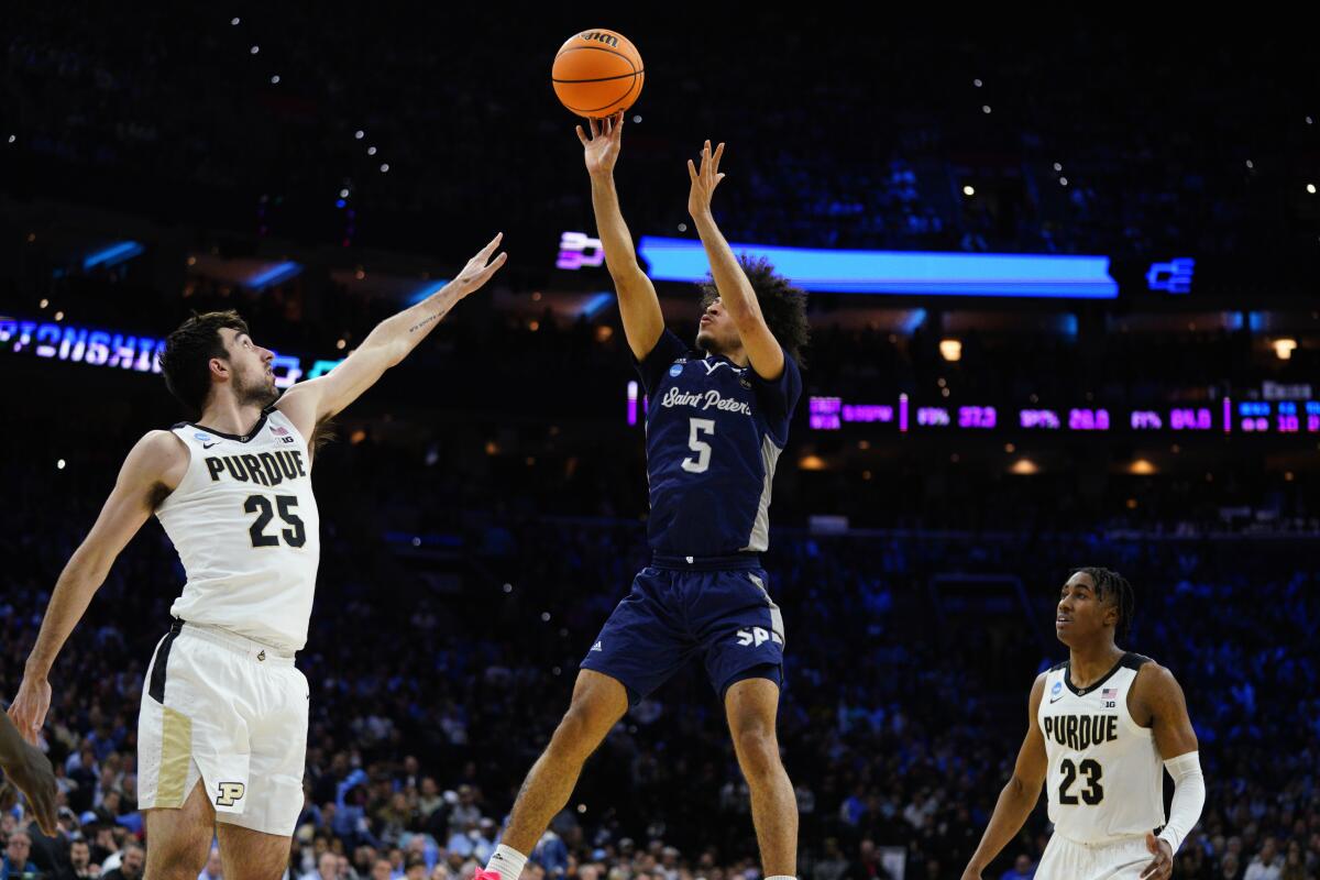 Saint Peter's Daryl Banks III goes up for a shot against Purdue's Ethan Morton, left, and Jaden Ivey on March 25, 2022.