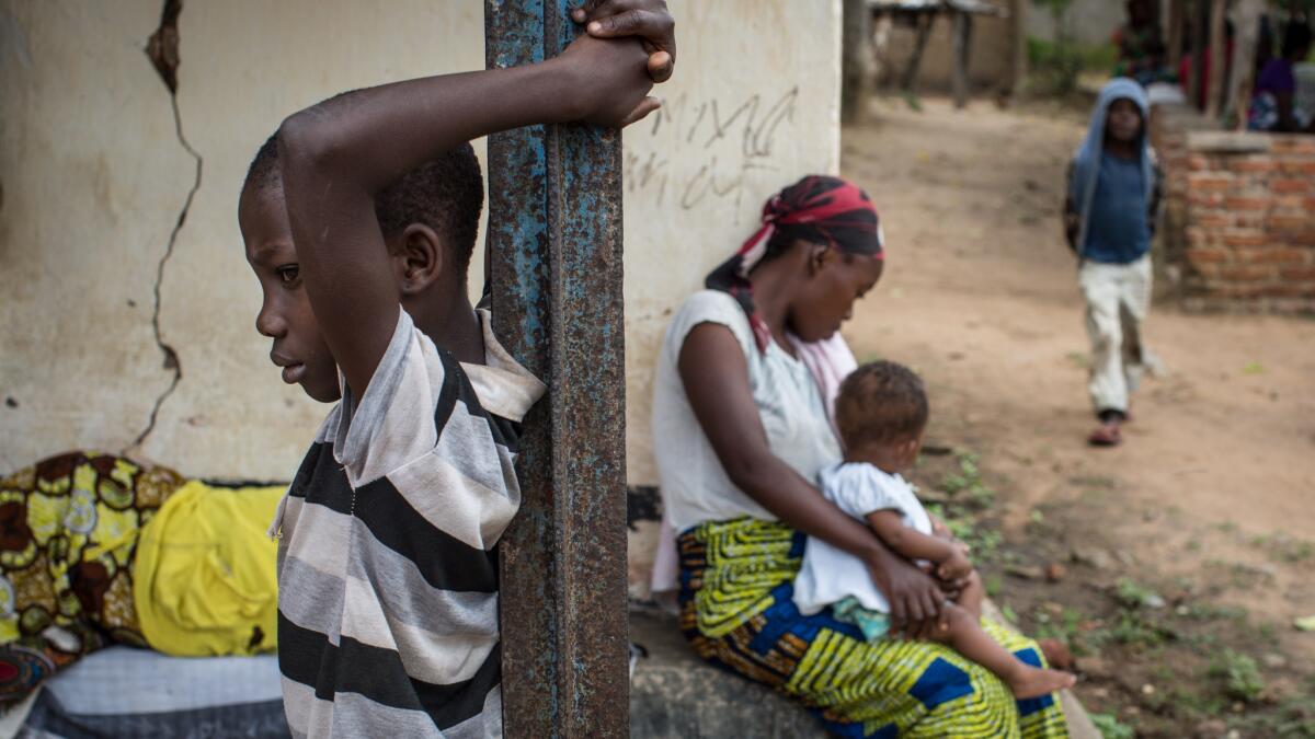 A woman and her children wait for medical attention in Luberizi, Congo.