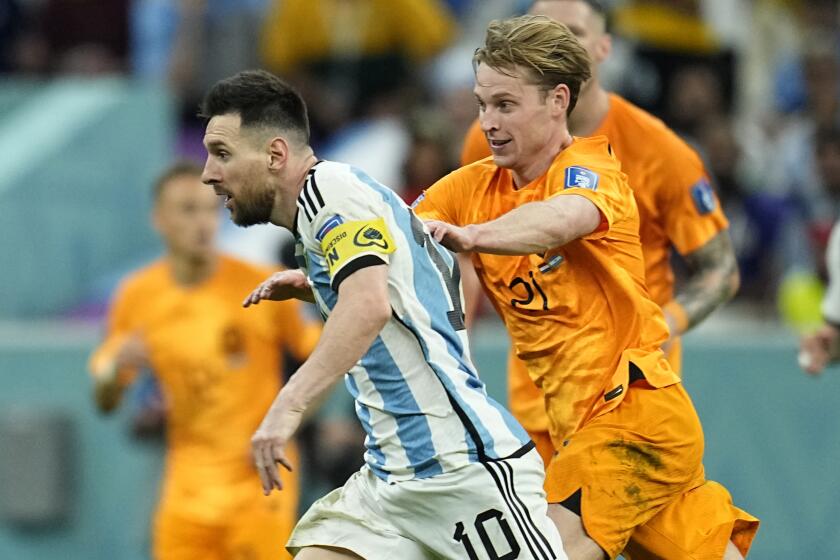 Argentina's Lionel Messi, front, duels for the ball with Frenkie de Jong of the Netherlands.