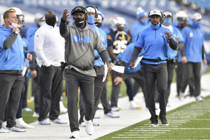 Los Angeles Chargers head coach Anthony Lynn, left, works the sideline during the second half of an NFL football game against the Buffalo Bills, Sunday, Nov. 29, 2020, in Orchard Park, N.Y. (AP Photo/Adrian Kraus)