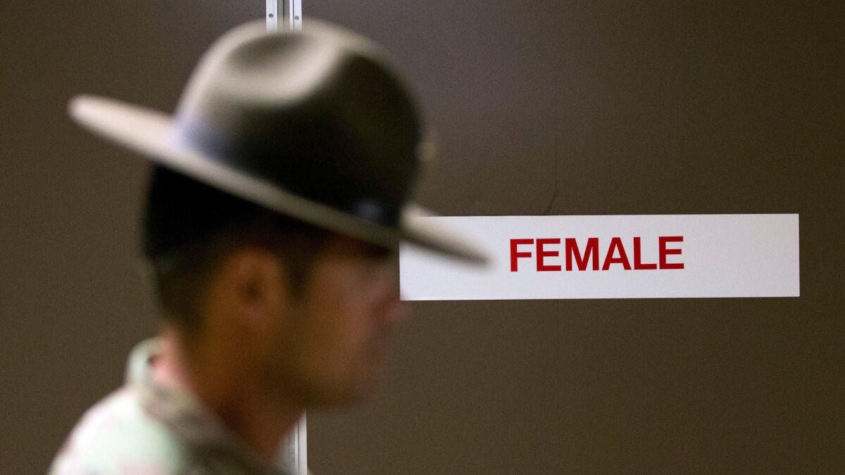 In this Oct. 4, 2017, photo, a U.S. Army drill instructor walks past a barracks for female recruits at Ft. Benning, Ga. As home to the previously all-male infantry and armor schools, Ft. Benning had to make a number of adjustments, including female dorms and security cameras.