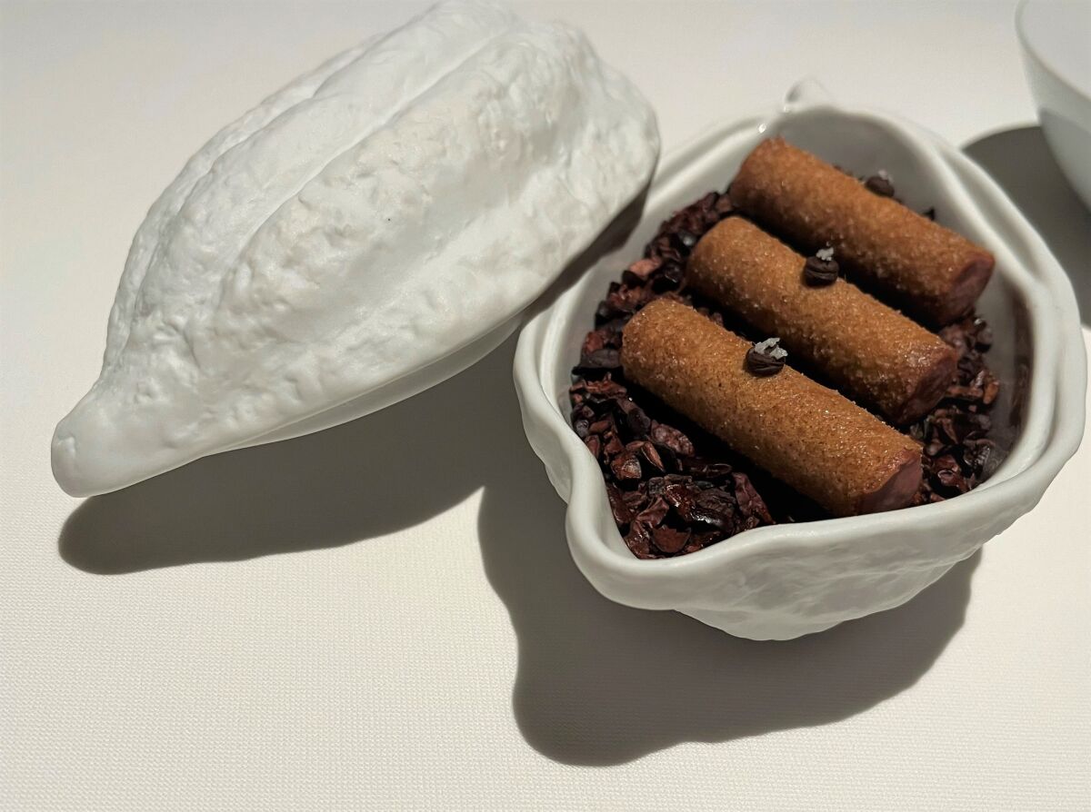 Chicken liver churros, served in a glass cacao pod dish filled with cocoa nibs at Addison restaurant. 