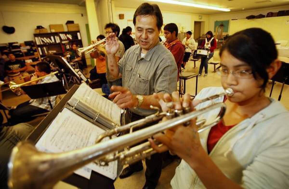 Belmont High School band director Brian Higa works with trumpeter Mayra Torres during Pep Band rehearsal at Belmont High School near downtown Los Angeles. The music program Higa has developed is scheduled to be eliminated.