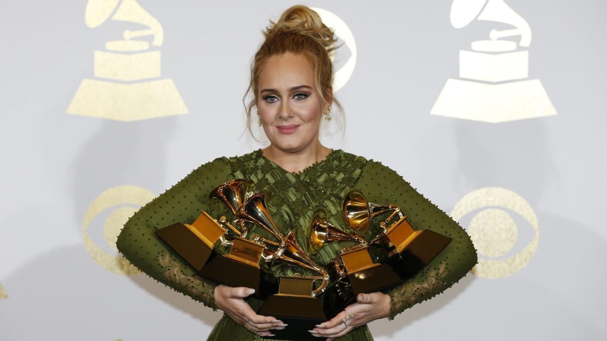 Adele is shown backstage in 2017 with her multiple Grammy Awards.